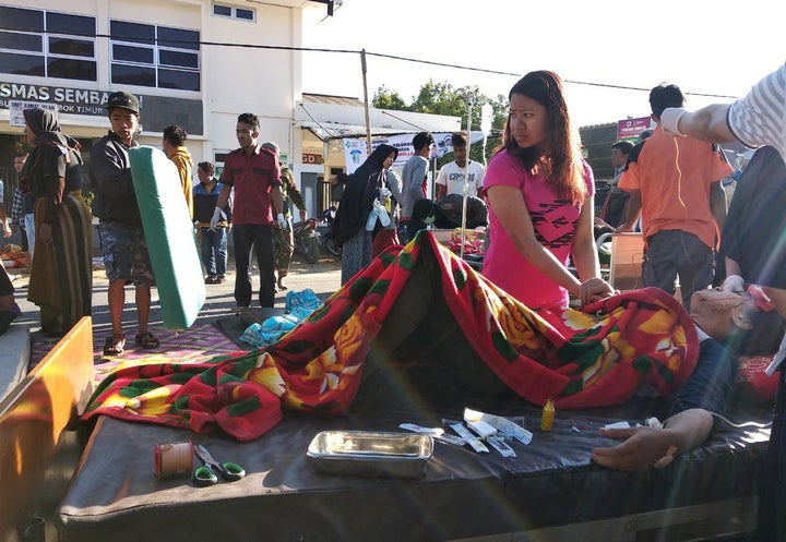 An injured person lies outside of a hospital after an earthquake hit Sembalun Selong village in Lombok Timur, Indonesia, July