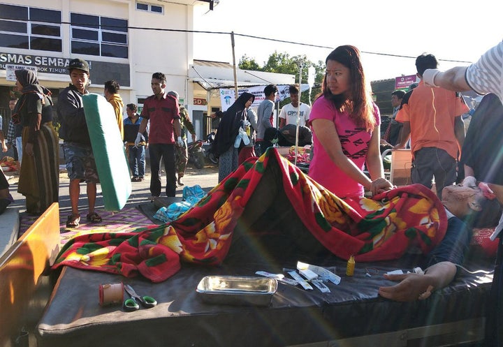 An injured person lies outside of a hospital after an earthquake hit Sembalun Selong village in Lombok Timur, Indonesia, July 29, 2018. 