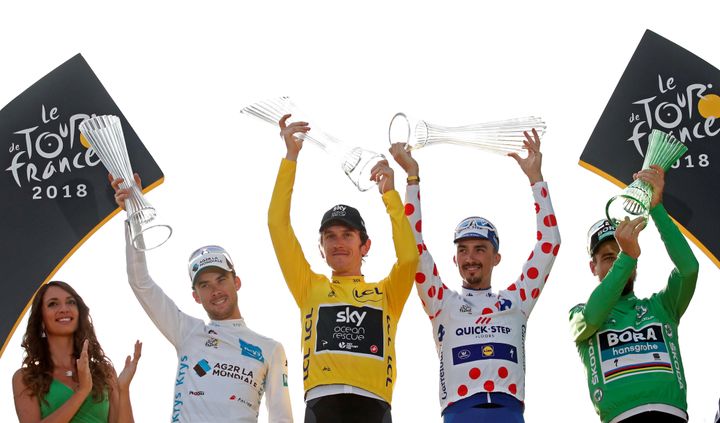 From left: Pierre Latour of France, wearing the white jersey for best young rider, Geraint Thomas of Britain, wearing the overall leader's yellow jersey, Julian Alaphilippe of France, wearing the polka-dot jersey, and Peter Sagan of Slovakia, wearing the green jersey, celebrate on the podium.