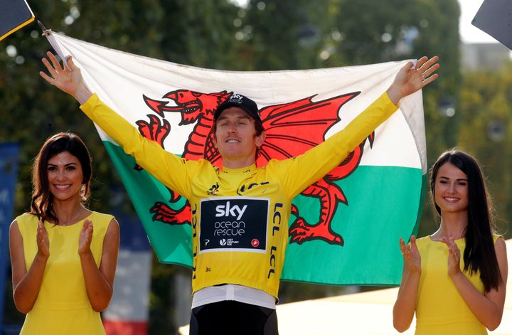 Team Sky rider Geraint Thomas of Britain celebrates his overall victory on the podium with a Welsh flag. 