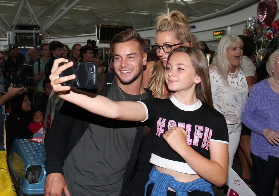 Chris Hughes and Olivia Attwood posing for photos at Stansted Airport 