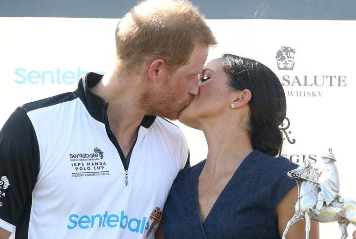 Meghan, Duchess of Sussex and Prince Harry kiss after posing with the trophy after the Sentebale Polo Cup on July 26 in Windsor, England. 