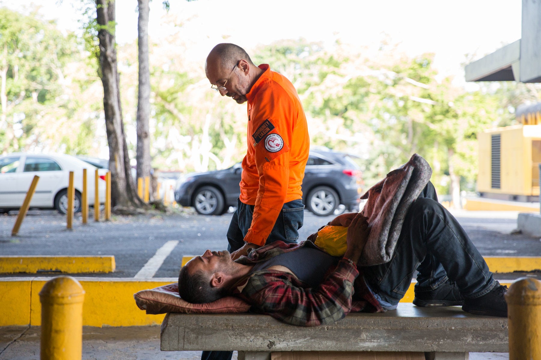 Victor Cajigas checks in on a homeless man living in front of Centro Medico Hospital after giving him water and fresh blanket