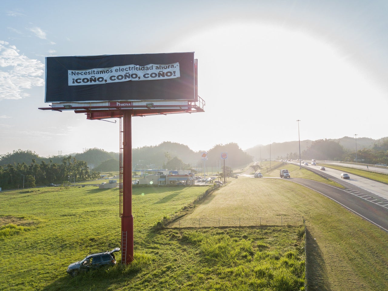 Kayak hangs a protest banner on a billboard just outside Vega Baja, Puerto Rico, on March 9, 2018. The banner reads: “We need electricity now! Damn, Damn, Damn!” Kayak prides himself in his unique style of activism that some consider reckless.