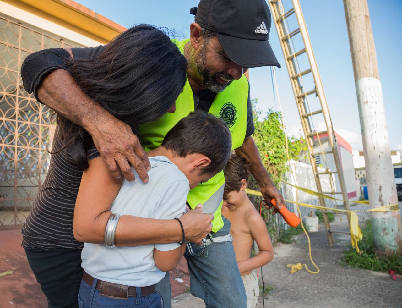 Kayak hugs Nadia Díaz, Aukai Spassor and Kalani Spassor after returning power to their apartment complex in San Juan, Puerto Rico, on March 14, 2018. They had been without usable power for more than a year despite being across the street from the Puerto Rican electrician's college. It took him two hours to restore power to 10 homes on that block.