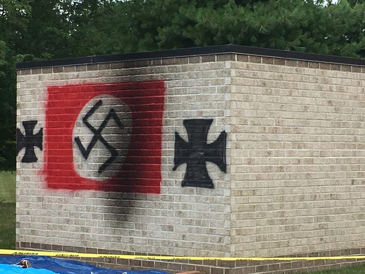 A photo shows a swastika and iron crosses painted onto property belonging to Congregation Shaarey Tefilla.
