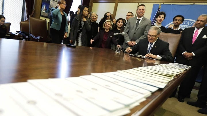 Washington Gov. Jay Inslee, a Democrat, signs a package of bills meant to address sexual misconduct at work.