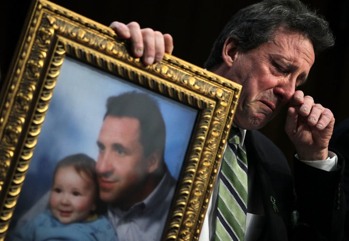 Neil Heslin, father of 6-year-old Sandy Hook victim Jesse Lewis, holds a picture of him with Jesse as he testifies during a hearing before the Senate Judiciary Committee in February 2013.