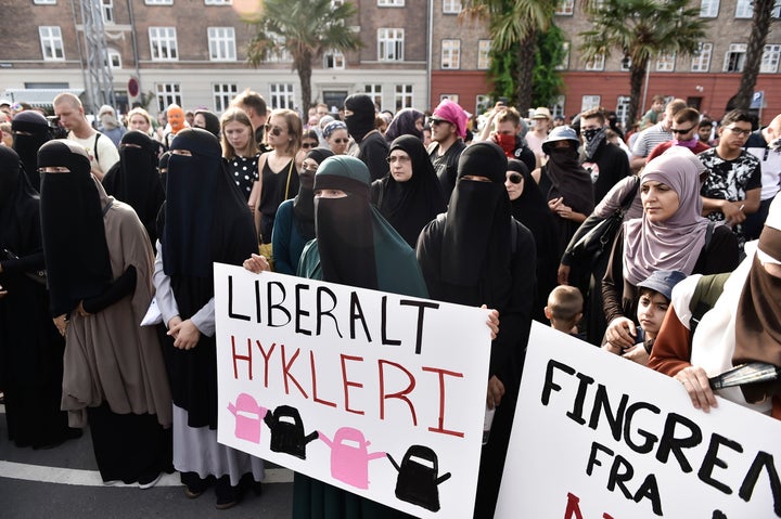 Women carry signs defending their right to wear Islamic face veils during a protest in Copenhagen on Aug. 1, 2018.