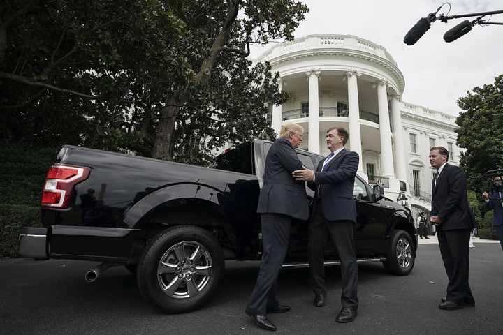 President Donald Trump, left, talks to Curt Magleby, vice president of government relations with Ford Motor Co., center, next to a Ford F-150 truck during a Made in America products showcase on the South Lawn of the White House in Washington D.C. on July 23.