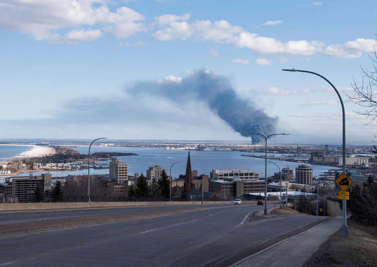 A fire at the Husky Oil Refinery in Superior, Wisconsin, is seen in the distance on April 26. Mitchell toured the site on a visit to the city.