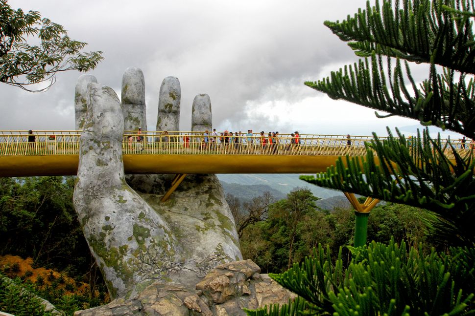 In this photograph taken on July 31, 2018, visitors walk along the 150-meter long Cau Vang "Golden Bridge" in the Ba Na Hills near Danang, Vietnam.