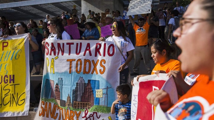 Demonstrators gather outside Austin City Hall to rally in support of the “freedom city” law passed in June to help counter Texas’ anti-sanctuary law. Cities and counties are increasingly facing off against state laws for and against protecting immigrants from deportation.