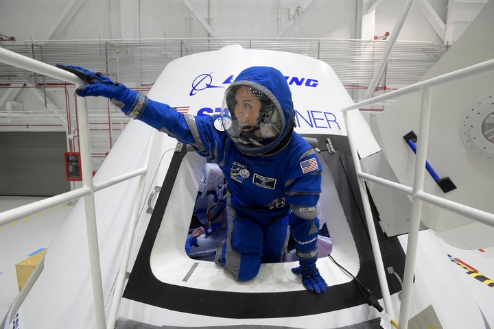 Boeing propulsion engineer Monica Hopkins climbs out of a mockup of the Starliner crew module, while wearing the craft's newly designed spacesuit.