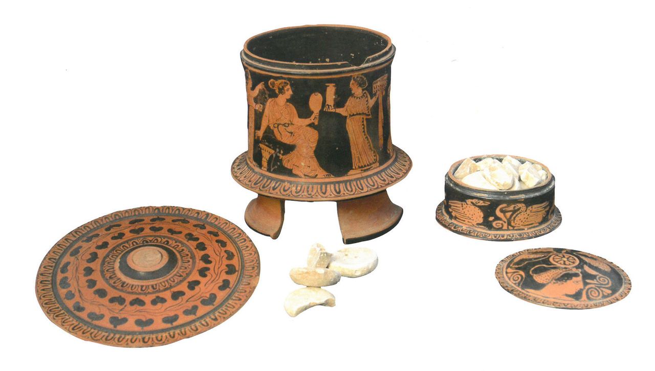 Ερυθρόμορφες κυλινδρικές πυξίδες. Η μία φέρει παράσταση γυναικωνίτη, ενώ η δεύτερη κοσμείται με ζώα. Βρέθηκαν σε θεμέλια σπιτιού στην Αθήνα, 410-420 π.Χ. Οι πυξίδες περιείχαν αλοιφές, πούδρες και καλλυντικές ουσίες.