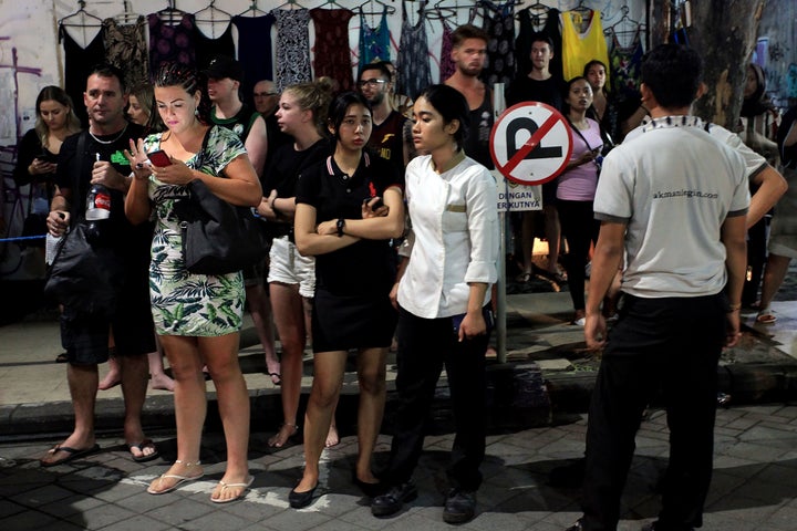 Foreign tourists and hotel staff stand on the street afer being evacuated in Bali's capital Denpasar on August 5, 2018, after a major earthquake rocked neighboring Lombok island. (HENDRA BROETAL/AFP/Getty Images)