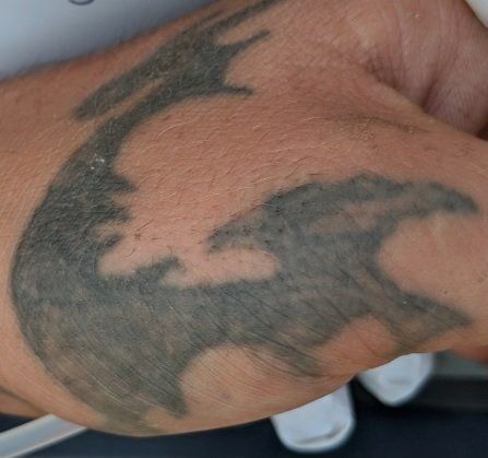 The man has a distinctive dragon tattoo, which police hope will help identify him 