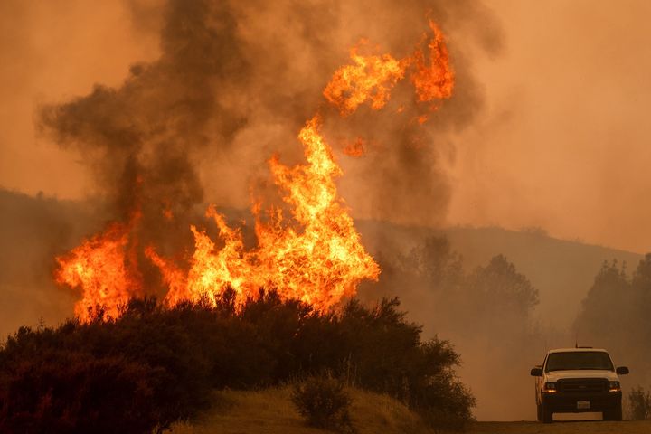 Flames leap above a vehicle on High Valley Road as the Ranch fire, part of the Mendocino Complex fire, burns near Clearlake Oaks, California, on Sunday.