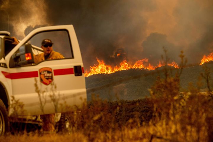 The Ranch fire, part of the Mendocino Complex fire, crests a ridge as Battalion Chief Matt Sully directs firefighting operations on High Valley Road near Clearlake Oaks, California, on Sunday.
