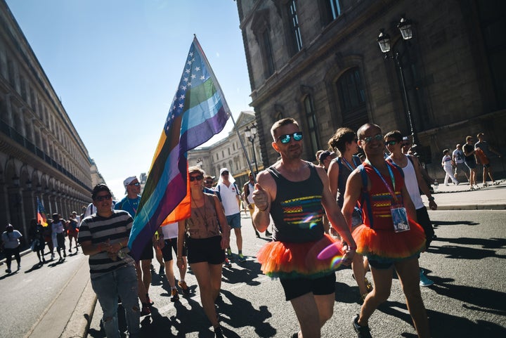 A man waves the rainbow flag as he takes part with others participants in the Rainbow Run, from Paris City Hall to Place de l