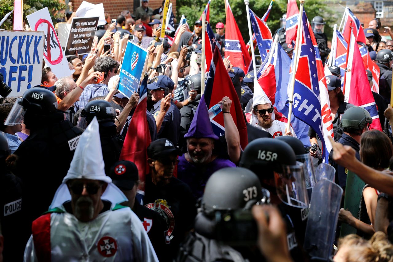 Riot police protect members of the Ku Klux Klan from counter-protesters as they arrive to rally in support of Confederate monuments in Charlottesville, Virginia, U.S. July 8, 2017.