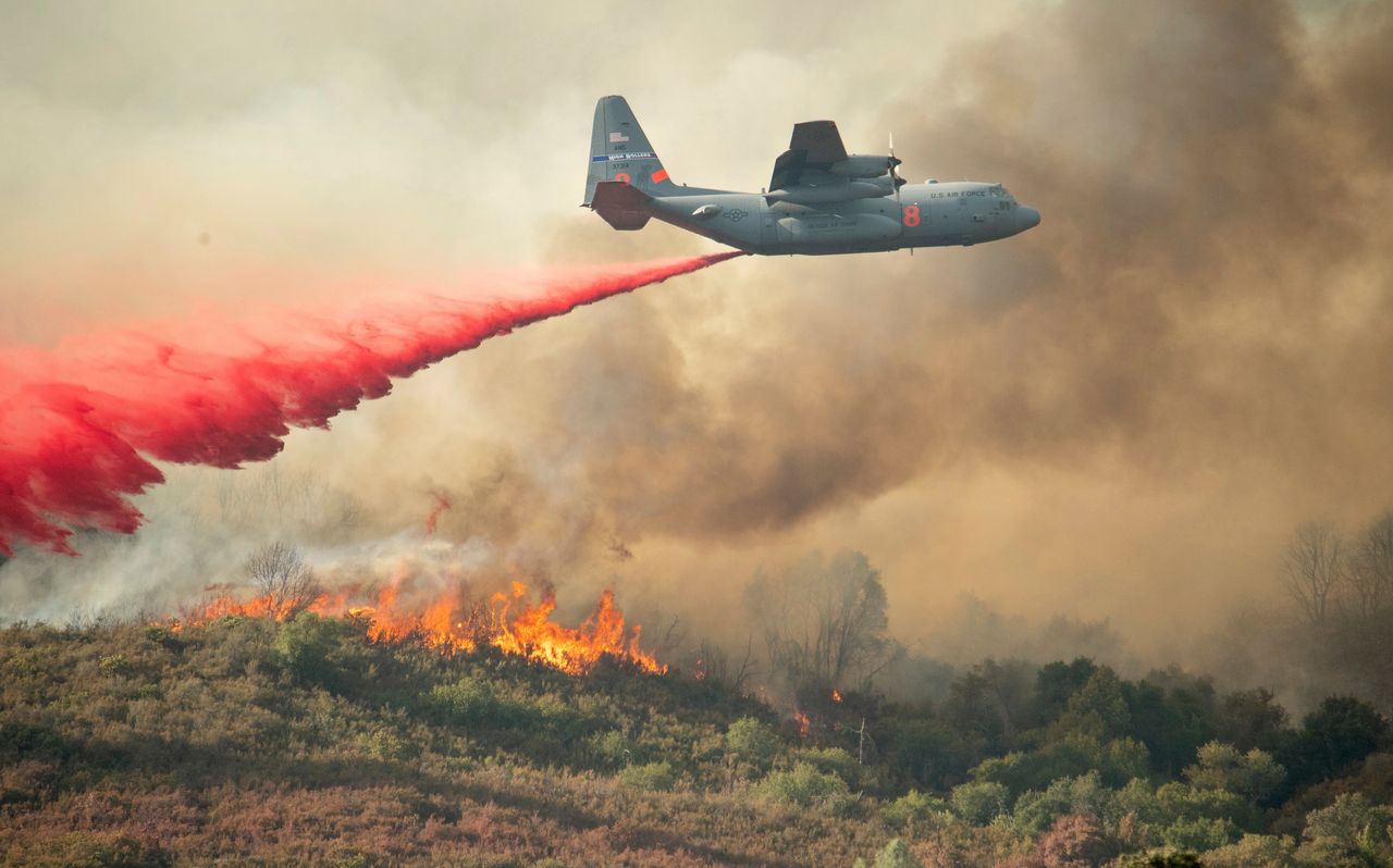 A U.S. Air Force plane drops fire retardant on a burning hillside in the Ranch Fire in Clearlake Oaks, California on Sunday, Aug. 5, 2018.