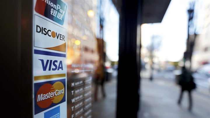 <p>Credit card logos are posted to the door of a business in Atlanta. U.S. household debt reached $13.2 trillion in the first quarter of this year, the 15th consecutive quarter increase.</p>