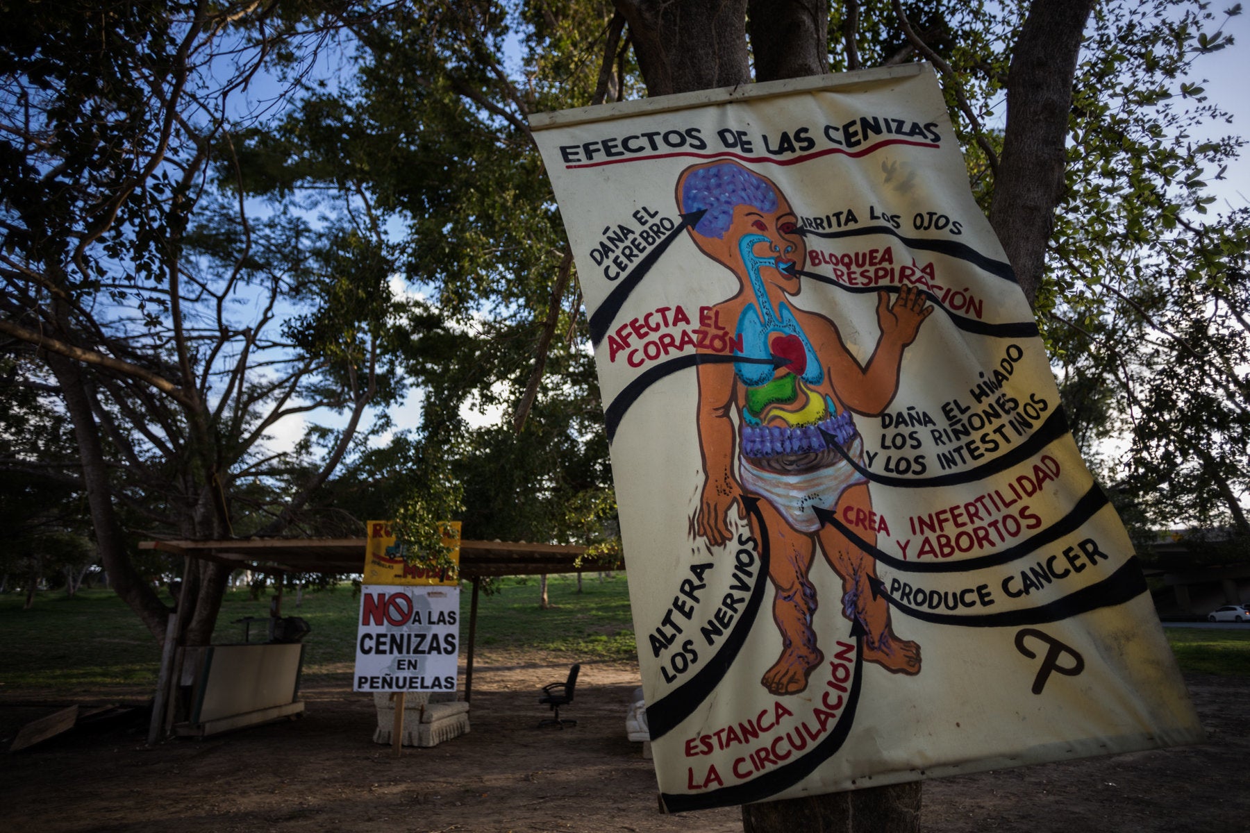 The sun sets on a protest camp in Peñuelas. A hand painted sign describes the effects that coal ash in the air and wat