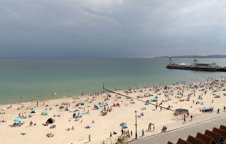 Storm clouds gather out at sea as people enjoy the warm weather on Bournemouth beach on Tuesday.