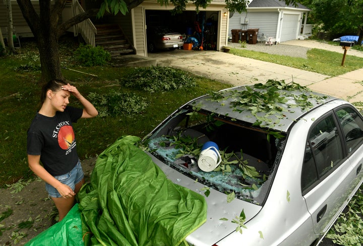 Sara Pilot, left, looks at the hail damage to her father's car outside of her home in Louisville, Colorado, on June 19.