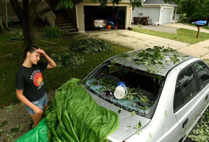 Sara Pilot, left, looks at the hail damage to her father's car outside of her home in Louisville, Colorado, on June 19.