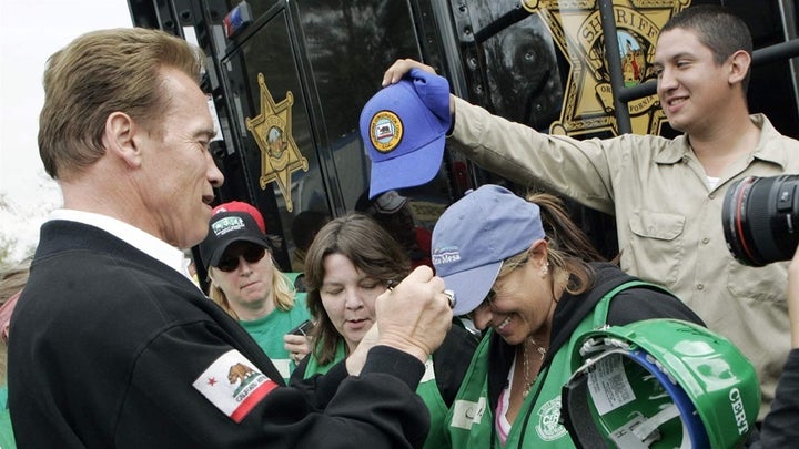 Former Republican California Gov. Arnold Schwarzenegger signs the cap of a Community Emergency Response Teams (CERT) member a