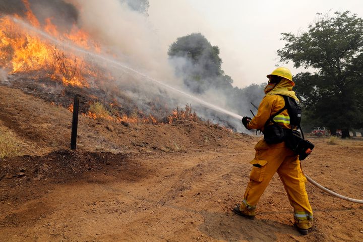 A firefighter uses a hose to knock down flames from the Ranch fire (part of the Mendocino Complex fire) north of Upper Lake, California, on Aug. 1.