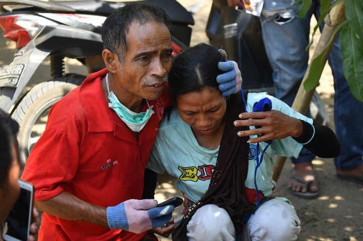 An Indonesian man tries to calm a woman after a strong aftershock hit Lombok island on Thursday.