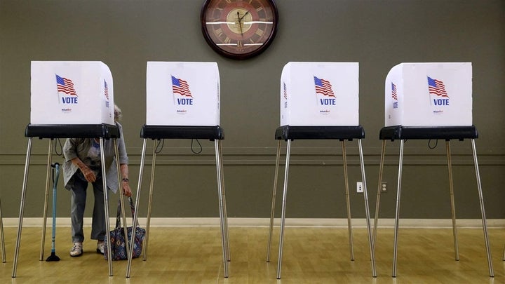 <p>A woman prepares to vote at a polling place in Silver Spring, Maryland, for the state’s June primary. Around 72,000 voters were mistakenly removed from rolls, causing confusion and low turnout. </p>