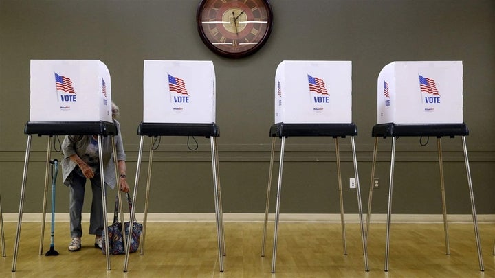 A woman prepares to vote at a polling place in Silver Spring, Maryland, for the state’s June primary. Around 72,000 voters were mistakenly removed from rolls, causing confusion and low turnout. 