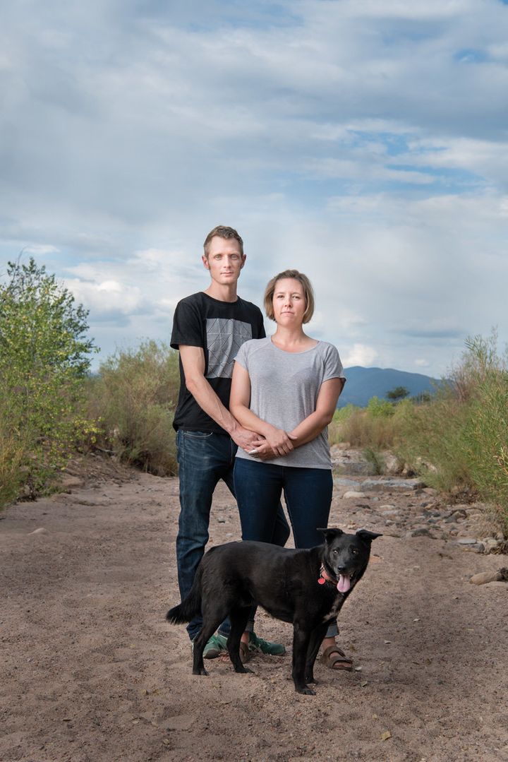 Colin Dyck and author Cally Carswell stand with their dog, Google, in the dry Santa Fe riverbed near their home in Santa Fe, New Mexico.