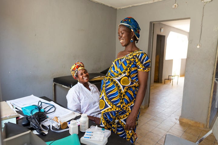 Oumou Traore, matron at Diaramana Health Centre, during an antenatal consultation with 31-year-old Fatoumata Sogoba, pregnant with her seventh child. Matron for 38 years, Oumou not only delivered Fatoumata herself, but all six of her children. This will be the first of Fatoumata’s children born at the health centre since it was given access to clean water. Diaramana, Mali, April 2016.