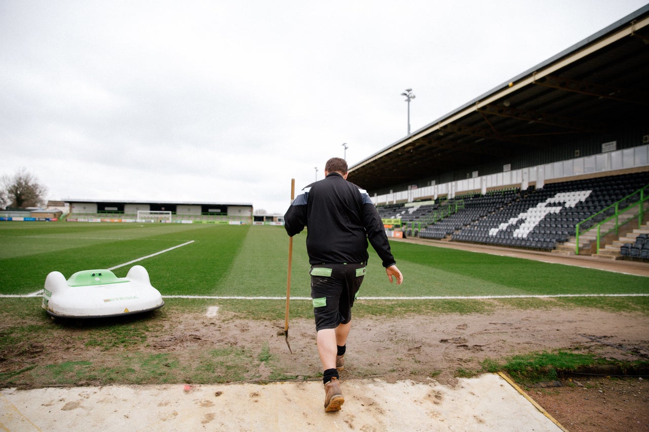 Groundsman Adam Witchell and the solar powered "mowbot" that cuts the grass at Forest Green Rover's stadium.