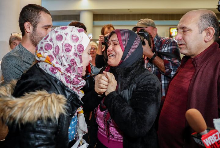 Syrian refugee Baraa Haj Khalaf (left) reacts as her mother Fattoum (center) cries and her father Khaled (right) looks on after arriving at O'Hare International Airport in Chicago on Feb. 7, 2017.
