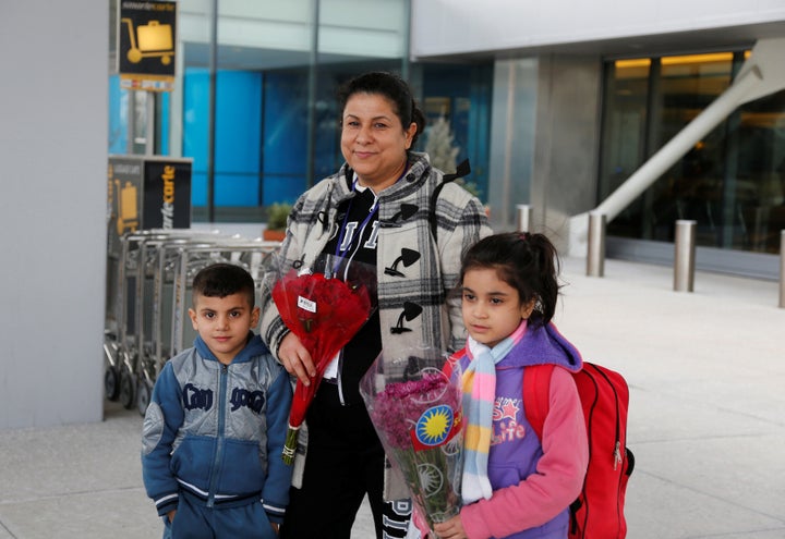 Iraqi refugee Amira Al-Qassab stands outside with two of her children as a relative picks them up at Detroit Metro Airport in Romulus, Michigan, on Feb. 10, 2017.