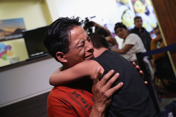 An emotional father embraces his son for the first time in months on Aug. 7, 2018, in Guatemala City, after nine children were flown from New York to reunite with their families.