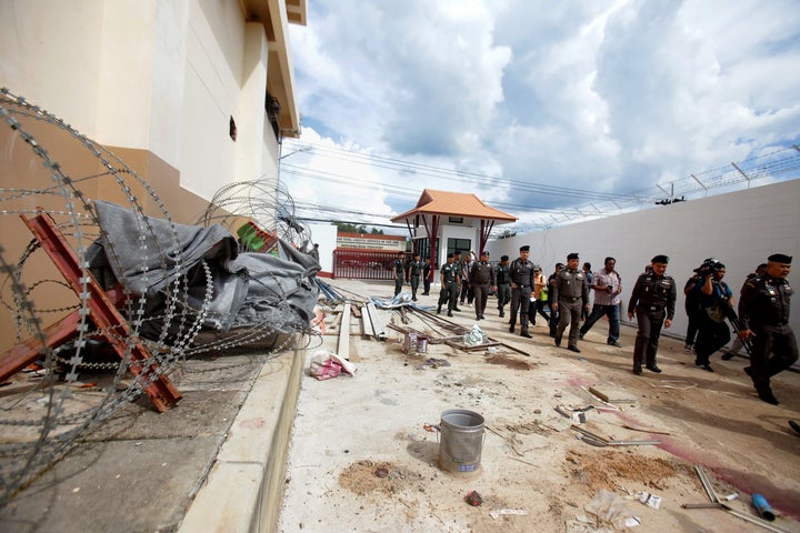 Chinese police inspect the exterior of an immigration detention centre, from which 20 ethnic Uighurs escaped on November 21,