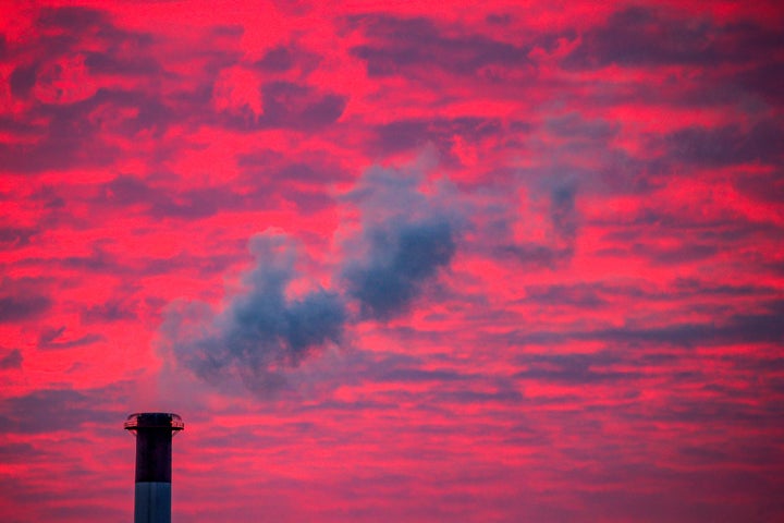 Steam rises from a smokestack at sunset in Lansing, Michigan.