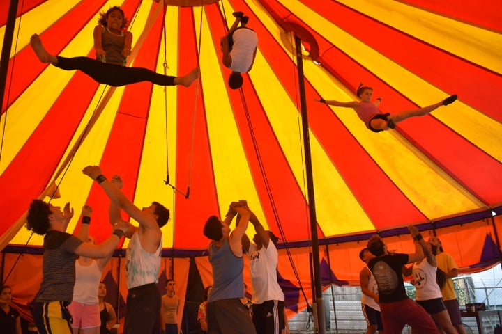 Students fly in the air during a trick in the tent in Dorado. 