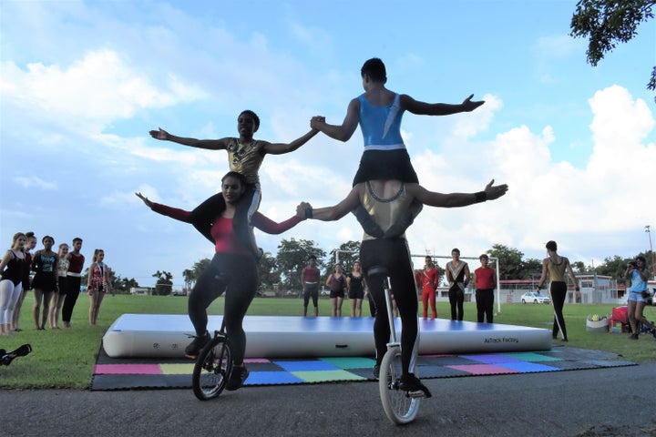 Students Ilka Miranda, Ari Maayan, Malik Leeks, and Finn McNamee perform a unicycle trick in Yabucoa.