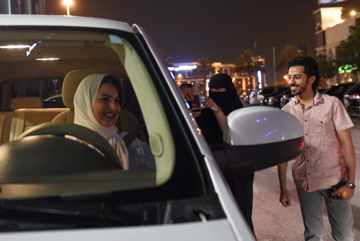 A Saudi woman films and shows support to Samar Almogren (left), who drives her car through the streets of the Saudi capital Riyadh for the first time just after midnight, June 24, 2018, when the law allowing women to drive took effect.