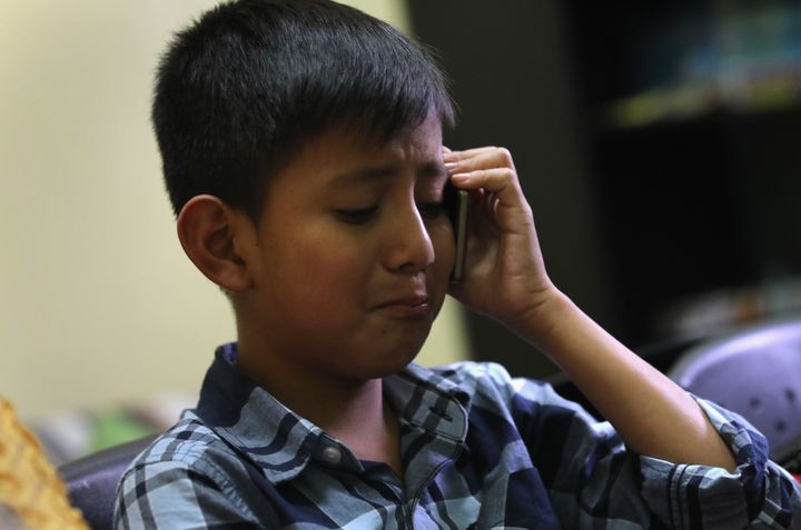 A 10-year-old child speaks with his mother on the phone after he was reunited with his father at the Nuestras Raices immigrant center on Aug. 7, 2018 in Guatemala City, Guatemala.