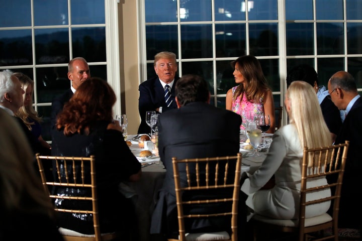 President Donald Trump sits with first lady Melania Trump as he meets with business leaders, Tuesday, Aug. 7, 2018, at Trump National Golf Club in Bedminster, N.J.