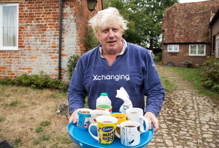 Boris Johnson brings out tea outside his house in Thame.